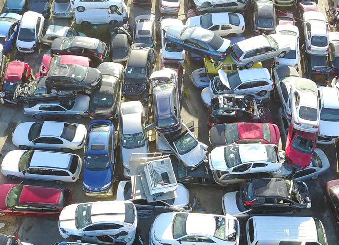 A wide view of a parking lot showcasing lot of damaged cars in Brisbane parked in organized rows in a scrapyard.