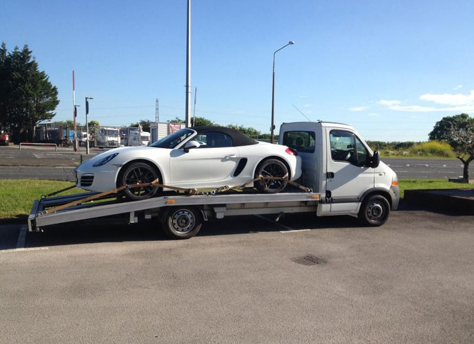 White sports car on a flatbed truck, representing same day car disposal services available in Brisbane.