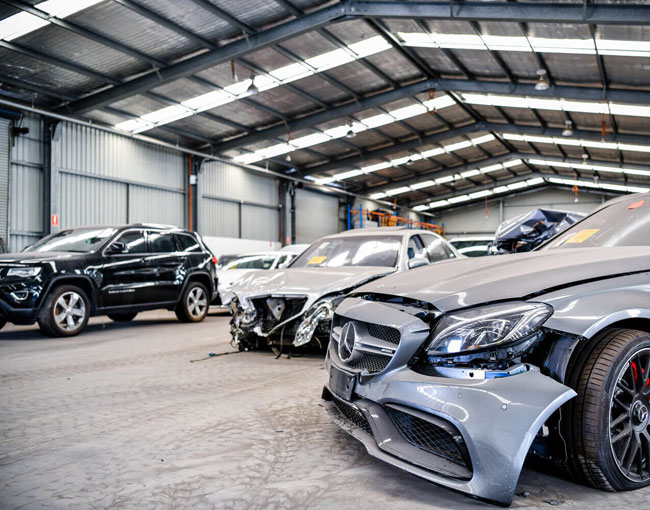 Multiple unwanted cars in a garage, featuring one that can be sold for Cash for Damaged Cars in Brisbane.
