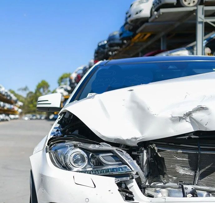 A white car with a visibly damaged front end, representing the urgency of Same Day Damaged Car Removal in Brisbane.