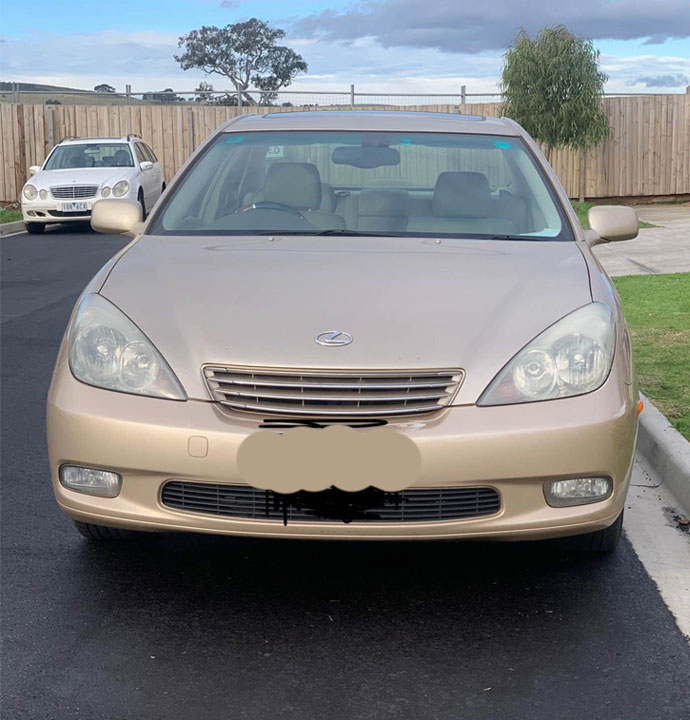 An old automobile parked along the street, advertising Instant Cash for unwanted Cars in Brisbane.